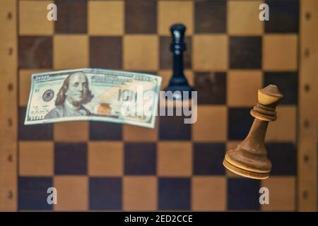 American dollars money and retro chessboard with chess pieces. Concept of problems of intellectual game, politics and money Stock Photo