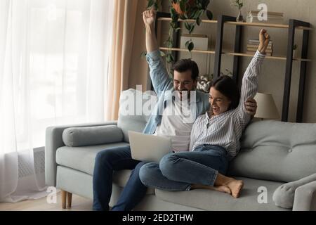 Shocked couple cuddle scream wow reading email with great news Stock Photo