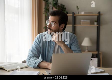 Thoughtful businessman analyze information in mind distracted from laptop screen Stock Photo