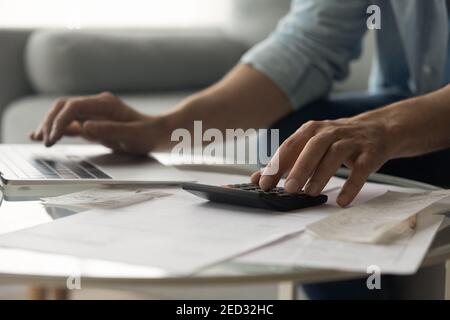 Man bookkeeper working with bills pay taxes online using laptop Stock Photo