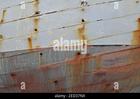 Close up of boat hull with rust marks and weather damage to painted wooden planks Stock Photo