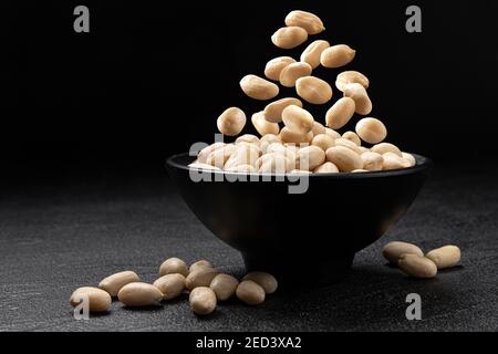Falling peanut on black background with copy space Stock Photo
