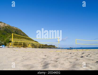 Yellow beach volleyball nets erected for use with no players yet on Mount Maunganui Main beach. Stock Photo