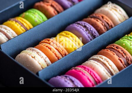 Various colorful macarons or French macaroons in a row in a gift box, sweet meringue-based confection made with egg white, icing sugar, granulated Stock Photo