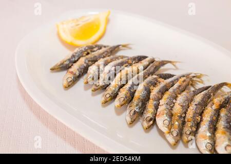 Espetos on plate. Espetos are skewer with sardines grilled beside the beach. Costa del Sol, Malaga, Spain Stock Photo