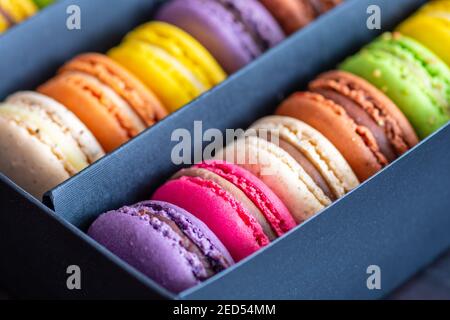 Various colorful macarons or French macaroons in a row in a gift box, sweet meringue-based confection made with egg white, icing sugar, granulated Stock Photo
