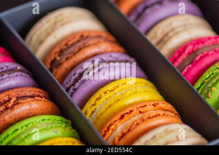 Various colorful macarons or French macaroons in a row in a gift box, sweet meringue-based confection made with egg white, icing sugar, granulated Stock Photo