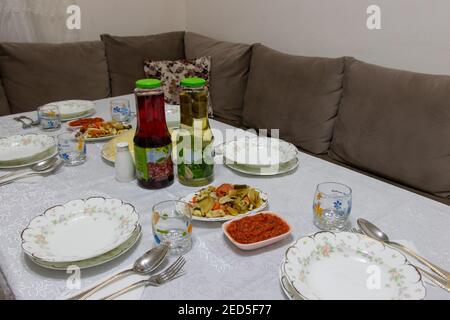 Family dinner table prepared for eating. The party begins in just a moment. Iftar time in Ramadan evenings Stock Photo