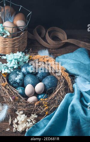 Beautiful Easter composition with painted quail and chicken eggs on a brown background. Stock Photo