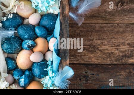 A large box filled with eggs of different sizes and colors, close-up. Stock Photo