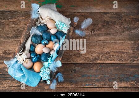 Beautiful Easter composition with painted and natural eggs on a wooden background. Stock Photo