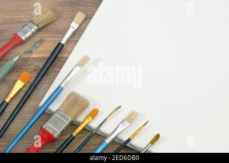 Different paintbrushes and white canvas. Free space for text or picture Stock Photo
