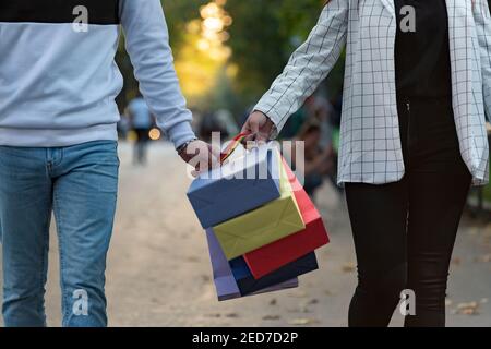 Close up multicolored paper shopping bags in hands Stock Photo