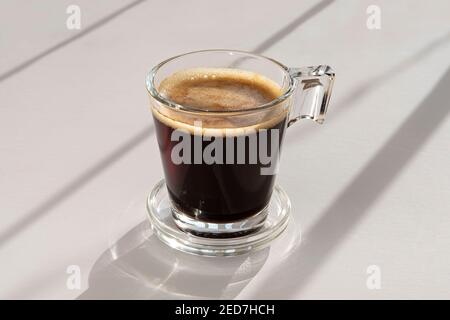 Black coffee in a glass cup and saucer Stock Photo