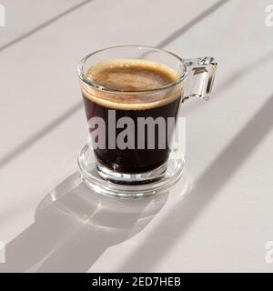 Black coffee in a glass cup and saucer Stock Photo