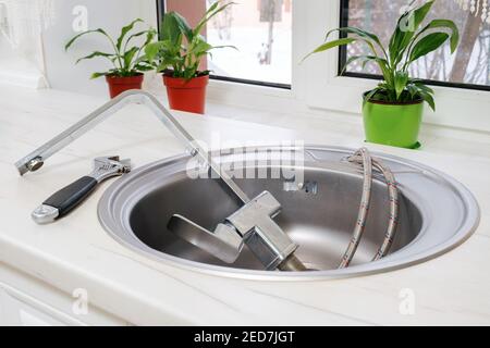 Removed old kitchen faucet in sink and tools Stock Photo