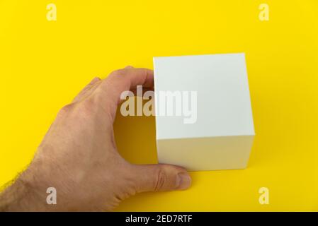 Mans hand holds small white cardboard box. Copy space. Mock up Stock Photo