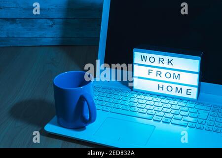 Laptop computer and coffee cup along with a light box indicating Work from home social distant work in time covid19 concept health with bluish light Stock Photo