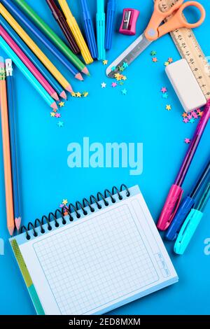 colorful school objects, ruler scissors, colors, on bright blue background Stock Photo