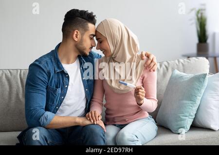 Loving muslim couple enjoying good news, waiting for baby Stock Photo