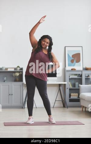Curvy girl stretching arms in gym Stock Photo - Alamy