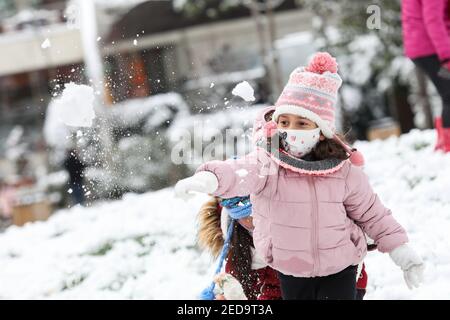 Tirana, Albania. 14th Feb, 2021. A girl throws a snowball at a park in Tirana, Albania, on Feb. 14, 2021. Credit: Gent Onuzi/Xinhua/Alamy Live News Stock Photo