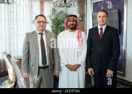 Group of successful business partners or delegates in formalwear standing in row in front of camera against interior of office or boardroom Stock Photo