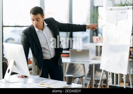 Confident business man communicate by video call with colleagues, discussing the project. Successful male employe making presentation, submit work report during online conference Stock Photo