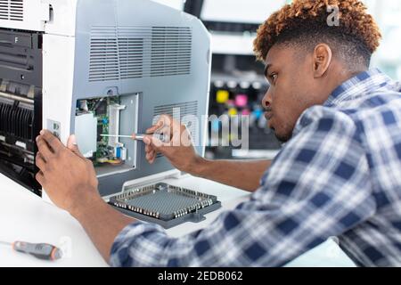 a focused technician repairing a machine Stock Photo