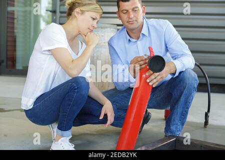 fire extinguisher salesman demonstrating operation procedure Stock Photo