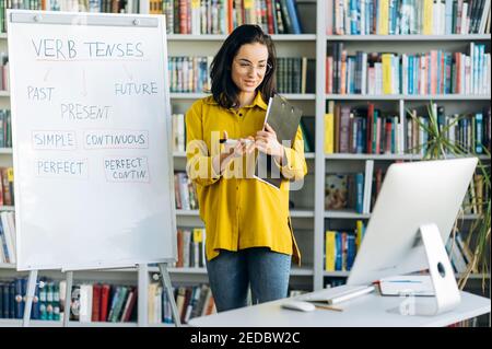 Online education. Confident smart smiling female teacher conducts online lesson for students via video conference. Training during quarantine Stock Photo