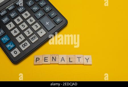 Phrase or word - penalty. Wooden block letter word and modern calculator on a yellow background, business concept with space for text Stock Photo