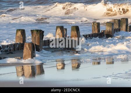 Winter sunlight on breaking waves on the North Norfolk coast, UK Stock Photo