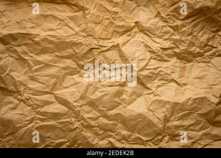 Ragged crumpled brown kraft paper texture background with wrinkles Stock Photo