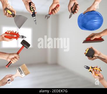 Many hands with different construction tools indoors Stock Photo