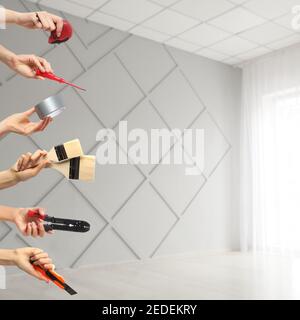 Many hands with different construction tools indoors Stock Photo