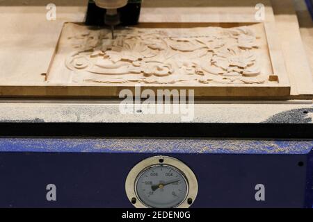 3D wood carving with CNC wood router machine. Selective focus. Stock Photo