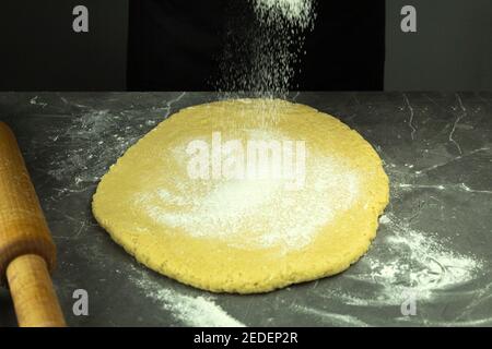 Dough rolled out with a rolling pin on the table. (copy space). Rolled dough on table with rolling pin with space for text Stock Photo