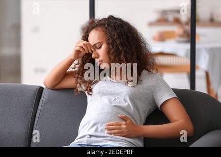 Stressed pregnant African-American woman at home Stock Photo