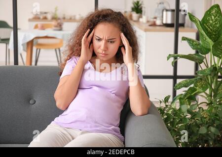 Stressed pregnant African-American woman at home Stock Photo