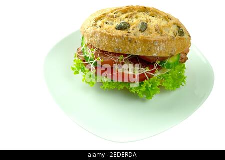 Burger with fried egg and bacon with vegetables. Sandwich on a white plate with copy space for text. Delicious cheeseburger with egg and bacon and che Stock Photo