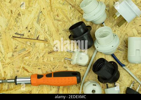 Installation of electrical wiring and connection of sockets and plugs to wires. Electrical objects and tools are spread out on the table with empty sp Stock Photo