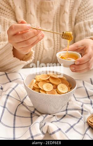 Woman with tasty pancakes, banana and honey on table, closeup Stock Photo