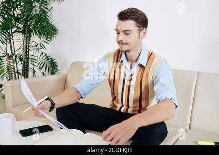Skeptical businessman checking documents Stock Photo