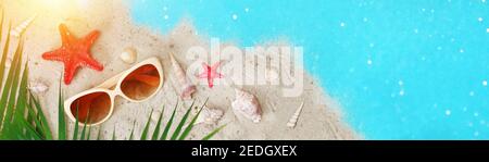 Tropical summer. Seashells, starfish on the sand by the sea. Tropical leaves. Summer time. Vacation, tourism, rest relaxation Stock Photo