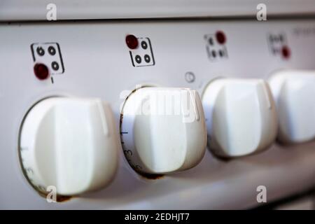 well-used white cooker buttons in a row with numbers Stock Photo