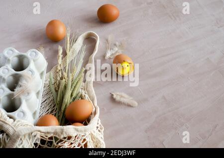 Happy Easter, the concept of preparing for the Feast of the Great Easter. A natural bag lies on a light background with a box for eggs, chicken unsaln Stock Photo