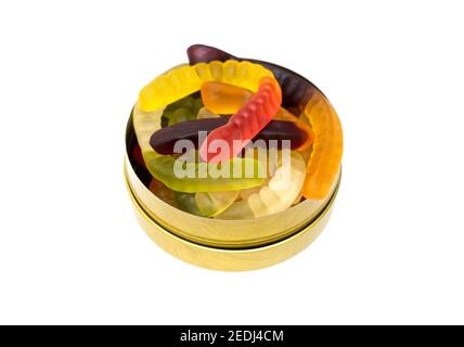 Mix of gummy worms in a round tin box isolated on white. Studio shot, top view, close-up. Stock Photo