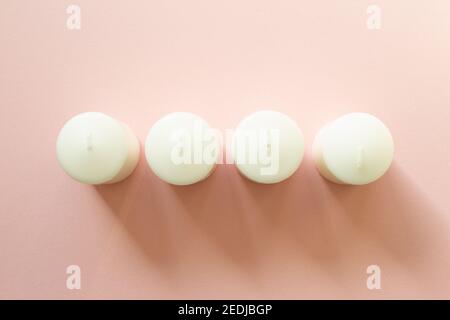 Aromatic white candles on pink background. flat lay, top view, copy space Stock Photo