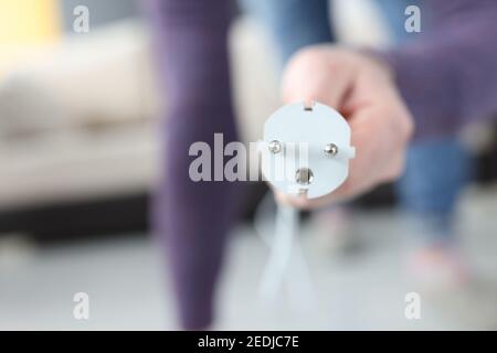 Male hand inserting plug into socket at home closeup Stock Photo